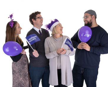 Two men and two women holding Epilepsy Society flags and balloons for Product photography
