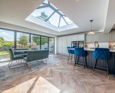 Wide shot of dining room and glass, patio doors with skylight overhead. Architectural photography