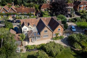 Ariel view of house surrounded by trees and grass.